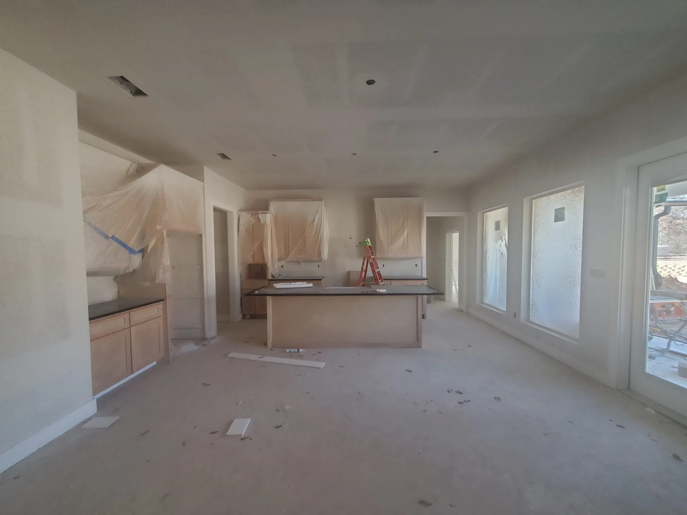 Open interior during construction, with drywall up and cabinets going in