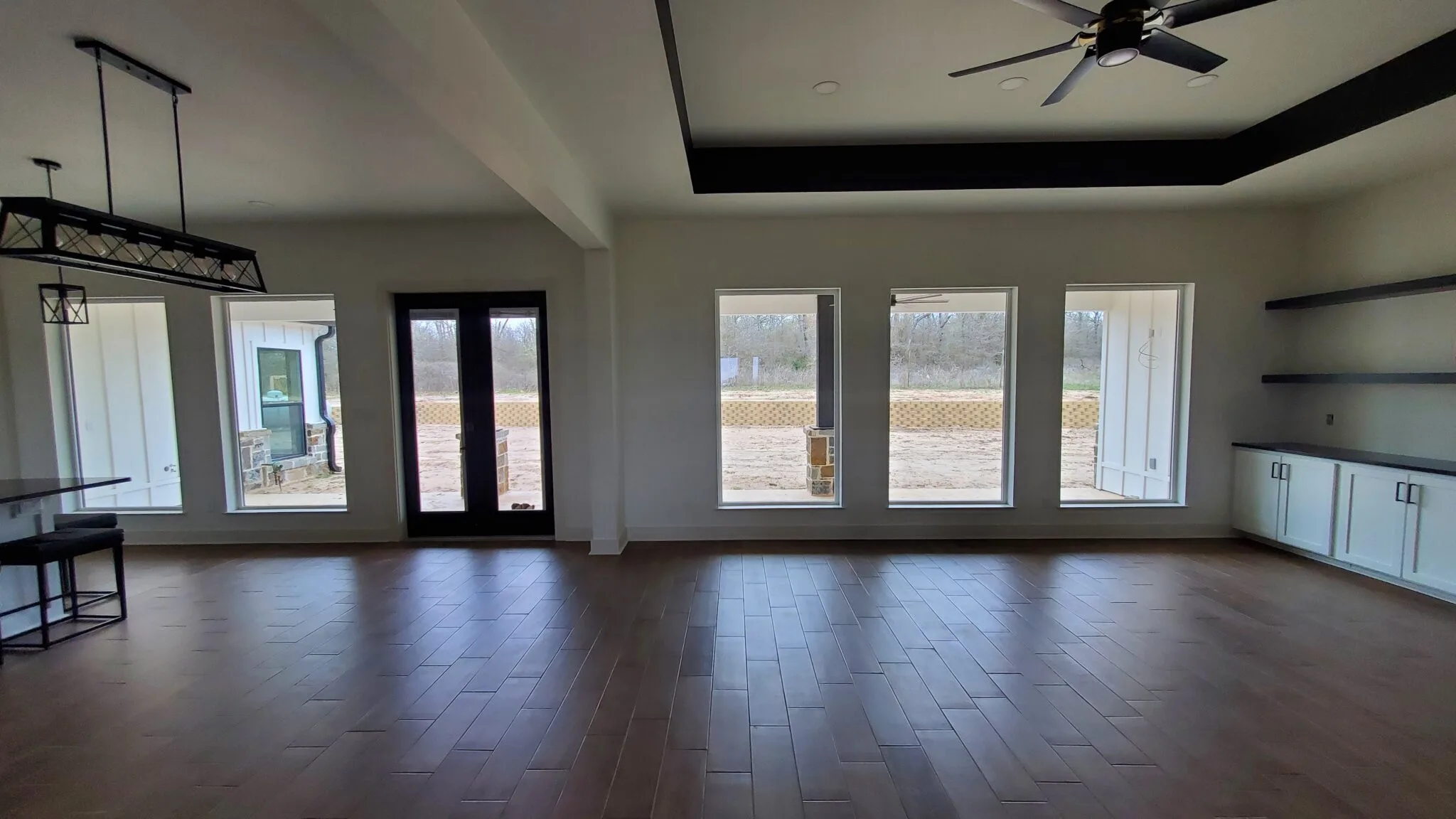 New addition with wood floors, a tray ceiling, a ceiling fan and French doors