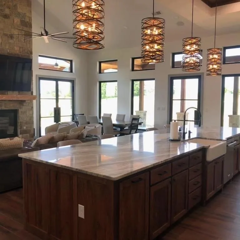 Kitchen island with a stone countertop and farmhouse sink, open to the living room