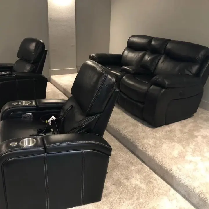 Black leather recliner theater seating on a gray rug
